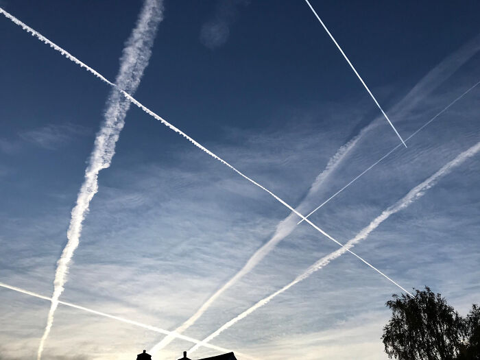 Sky filled with multiple aircraft contrails symbolizing conspiracy theory moments explained by facts