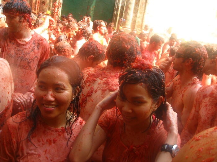 People covered in tomatoes participating in traditional tomato festival