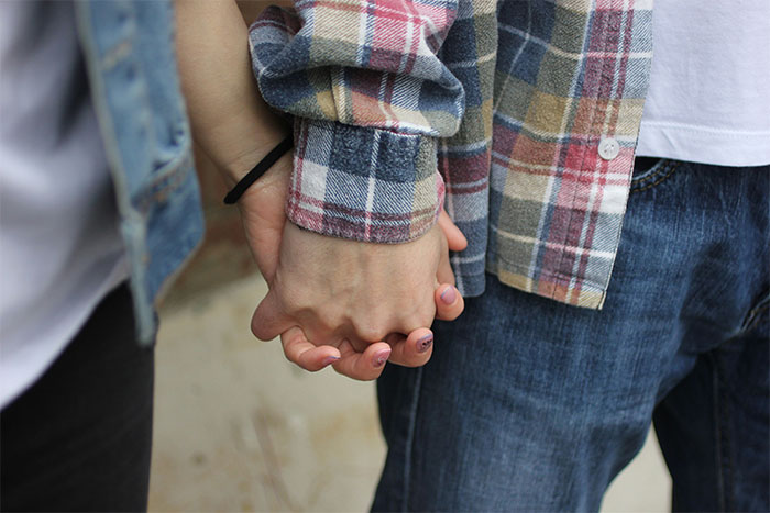 Close-up of couple holding hands in insular community