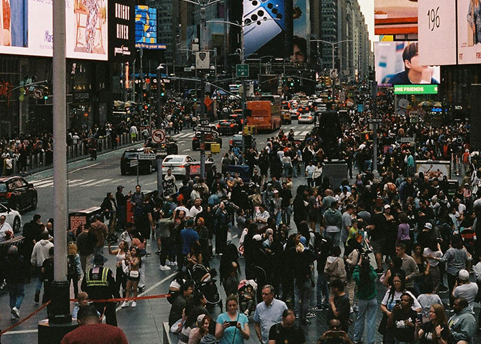 Crowded Times Square with people and traffic, challenging US stereotypes about city life.