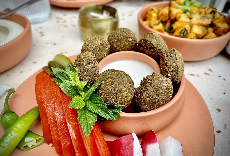 A healthy meal with falafel, fresh vegetables, and dip. This picture contrasts with the global report on countries with the worst diets.