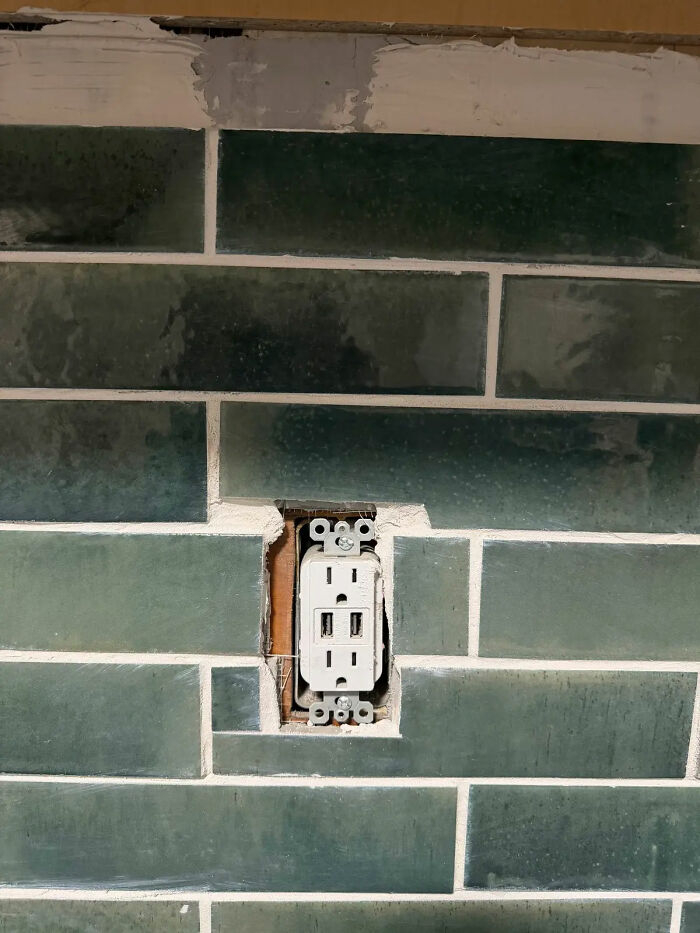Poorly cut tile around an electrical outlet; evidence of a very expensive contractor's shoddy work on a home.