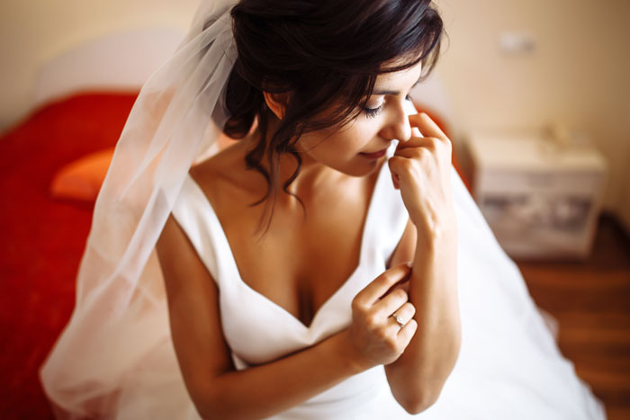 Bride in wedding dress adjusting veil showing bridezilla behavior
