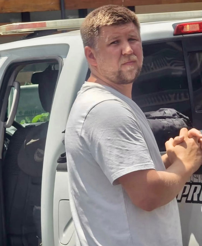 Man in white shirt involved in tourist lawyer case near vehicle