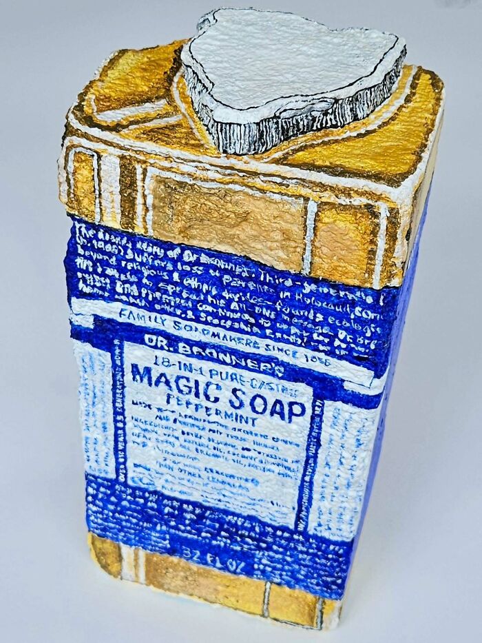A colorful stone creation resembling Dr. Bronner's Magic Soap bottle, transforming a rock into an iconic product.