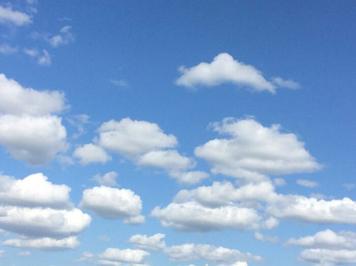Blue sky with fluffy white clouds scattered across