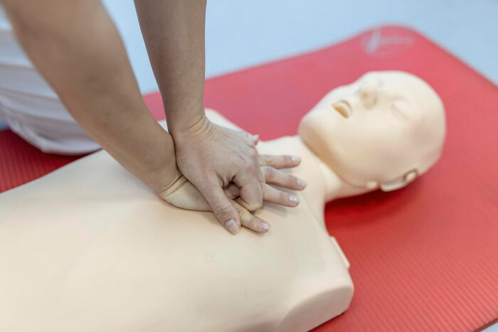 A person performing CPR on a medical dummy, highlighting lifesaving skills and lessons that will stay with you.