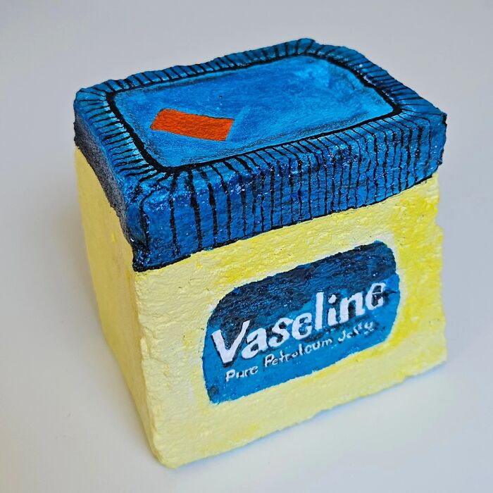 A colorful stone creation painted as a Vaseline jar. This artwork turns rocks into iconic foods and famous products.