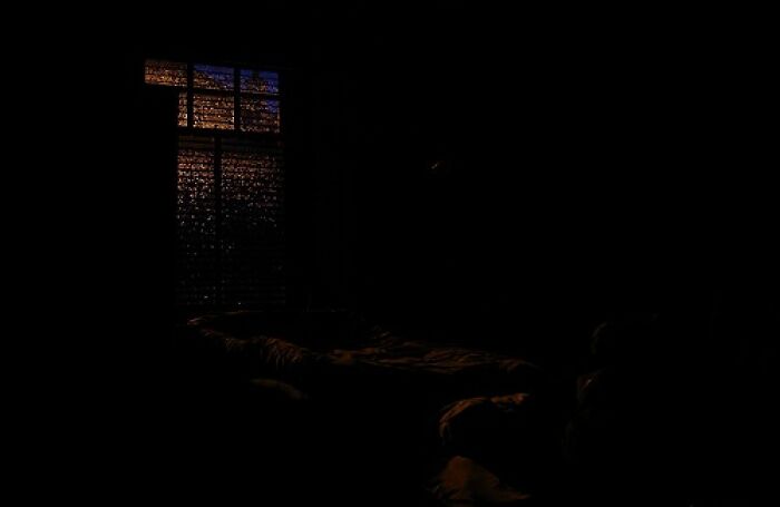 Dark room with a faintly lit window resembling a spooky Backrooms level