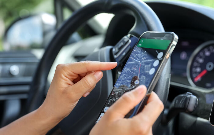 Person using smartphone navigation inside car symbolizing conspiracy theory moments explained by facts