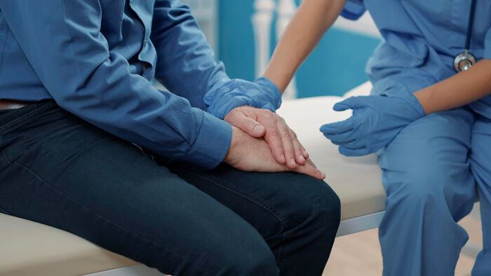 Patient holding hands with nurse in psychiatric facility support session