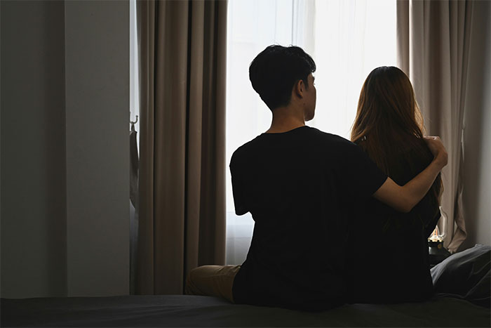 Couple sitting in dark room showing restrictive religious community theme