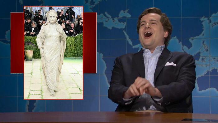 A person dressed as a walking statue, similar to the Statue of Liberty, and a man laughing at the Met Gala outfits. A person dressed as a walking statue, similar to the Statue of Liberty, and a man laughing at the Met Gala outfits.