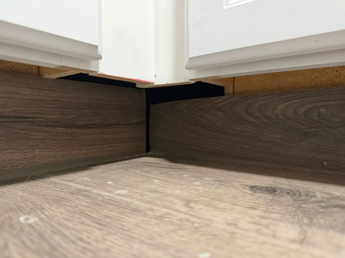 Poor contractor work: unsightly gaps where baseboard meets wall, showcasing a homeowner's frustration with their expensive contractor.