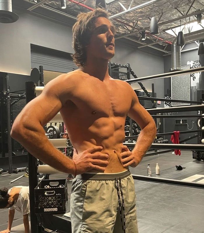 Lean muscular man posing in gym highlighting athletic physique