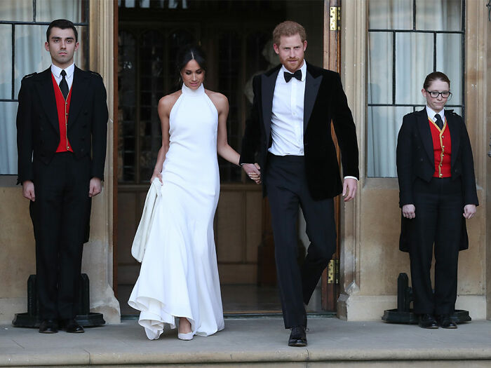 Meghan Markle and Prince Harry dressed formally walking out of building