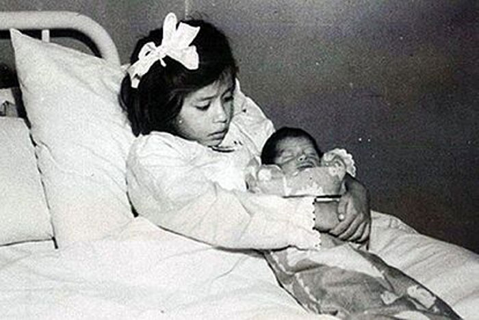 Young girl holding newborn baby lying on hospital bed anxiety-inducing truths