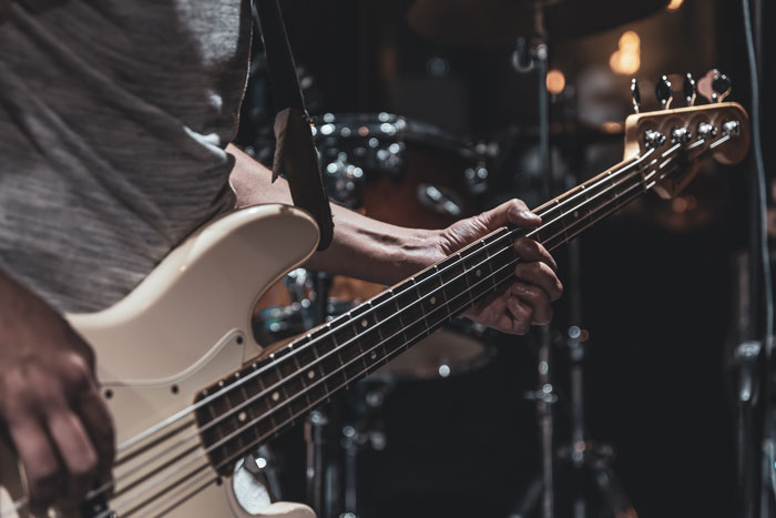 Musician playing electric bass guitar during live performance