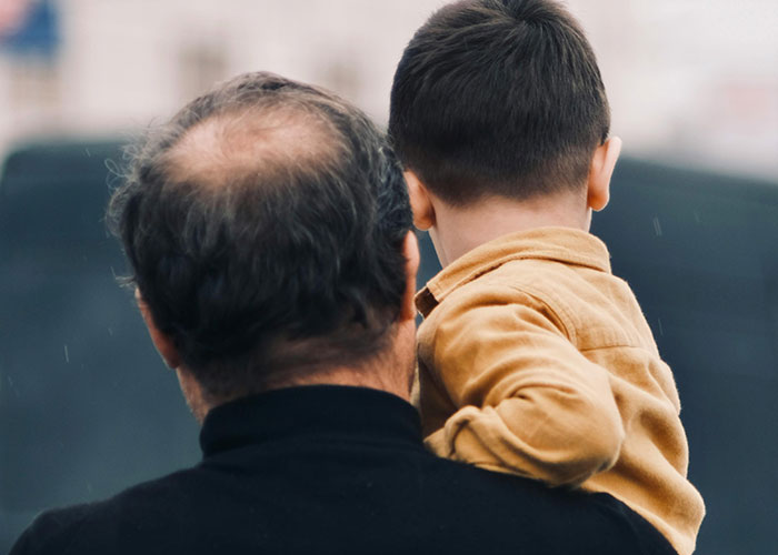 Man carrying a child symbolizing families affected by mysterious vanishings