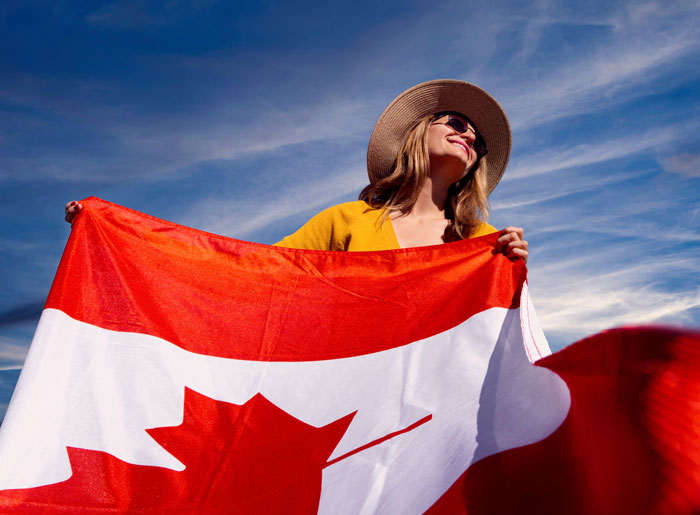 Woman holding Canadian flag outdoors symbolizing unique statistics