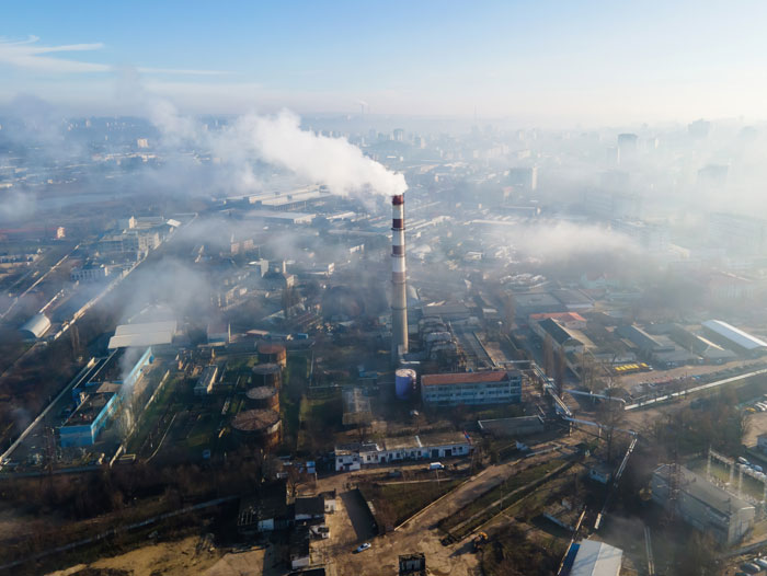 Industrial pollution with factory smokestacks emitting smoke over a city