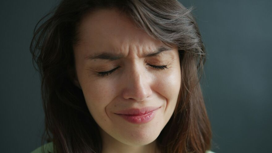 Close-up of woman happily crying with eyes closed and slight smile