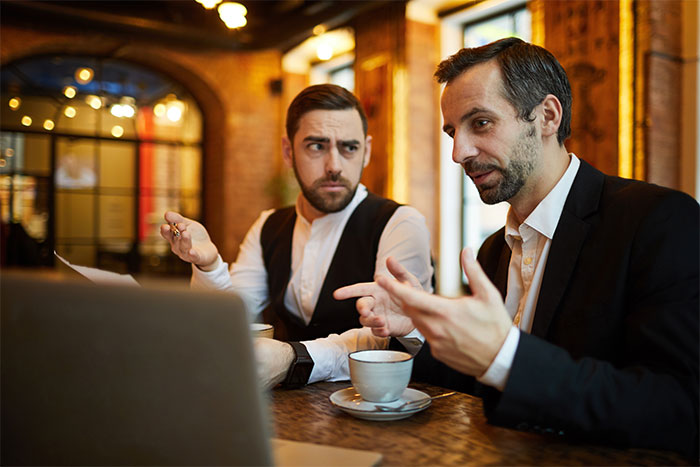 Boss angrily discussing business issues during a tense dinner meeting Boss angrily discussing business issues during a tense dinner meeting