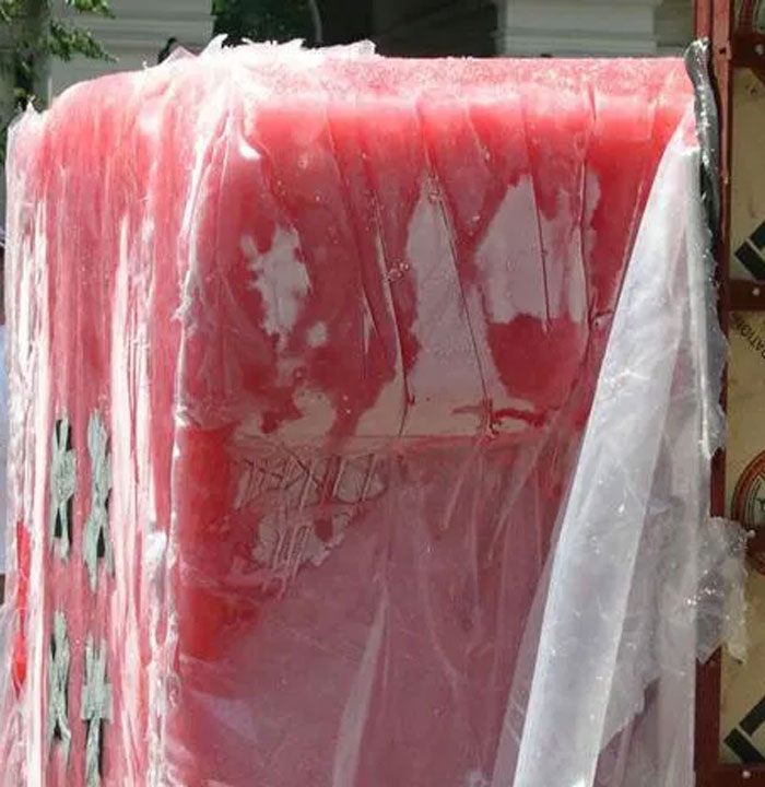 Red plastic shrink wrap partially covering a large crate
