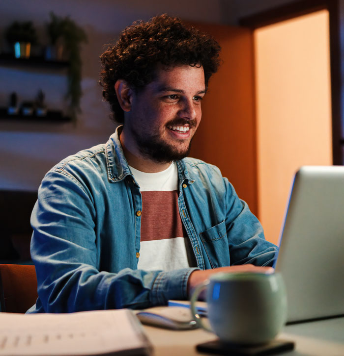 Smiling man working on laptop symbolizing overcoming anxiety with therapy