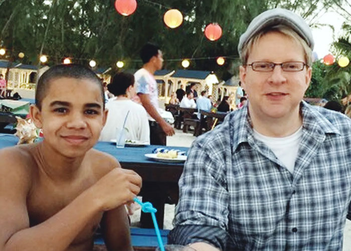 Two men sitting outdoors enjoying food and drinks