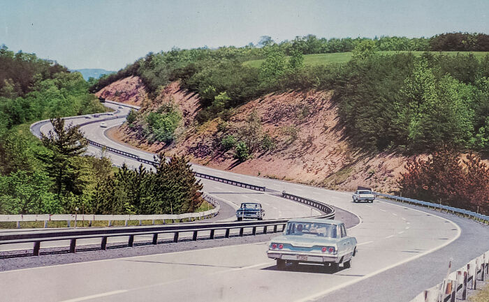 Vintage photo of winding road with cars on a curvy highway