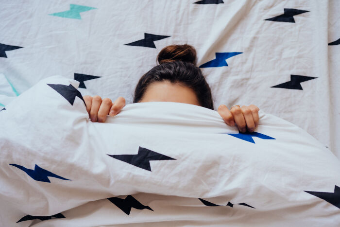 Person hiding under blanket in psychiatric facility setting