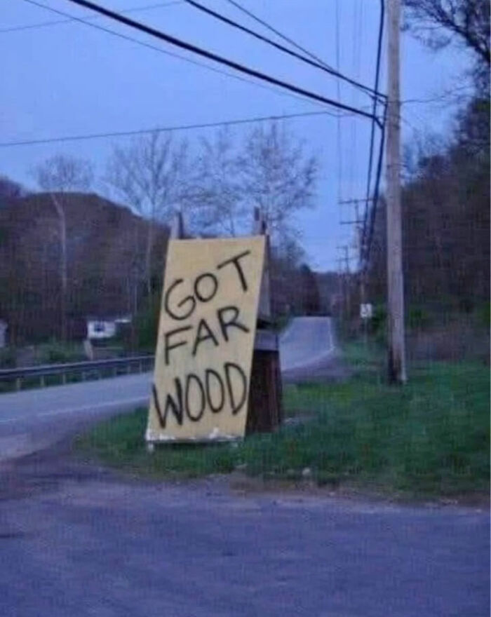 Handmade sign on roadside reads Got Far Wood in black letters