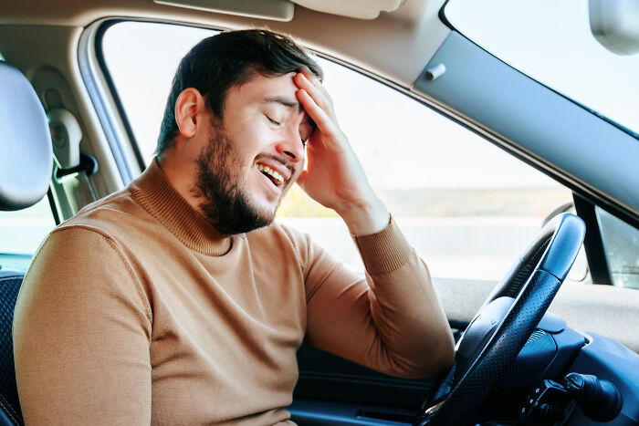 Man in car with frustrated expression showing brain on autopilot