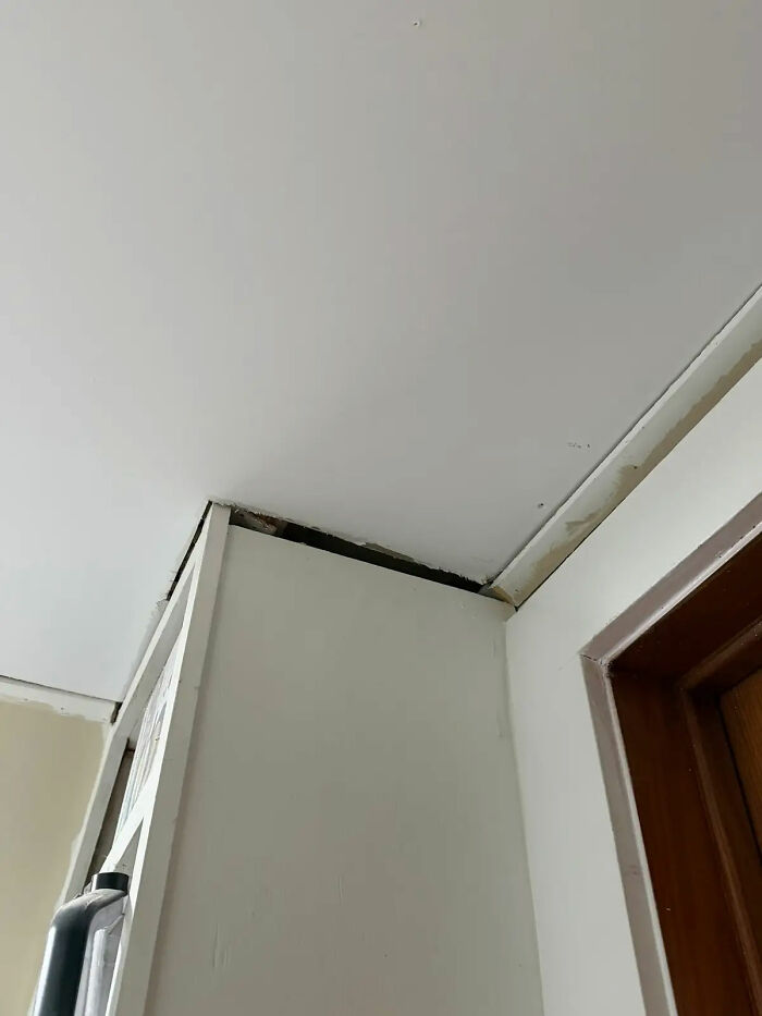 Poor contractor work: unsightly gaps between a white ceiling and walls/cabinets, revealing unfinished construction.