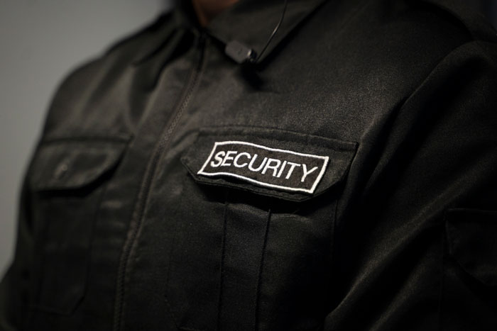 Close-up of black security uniform badge showing glitch in the matrix security