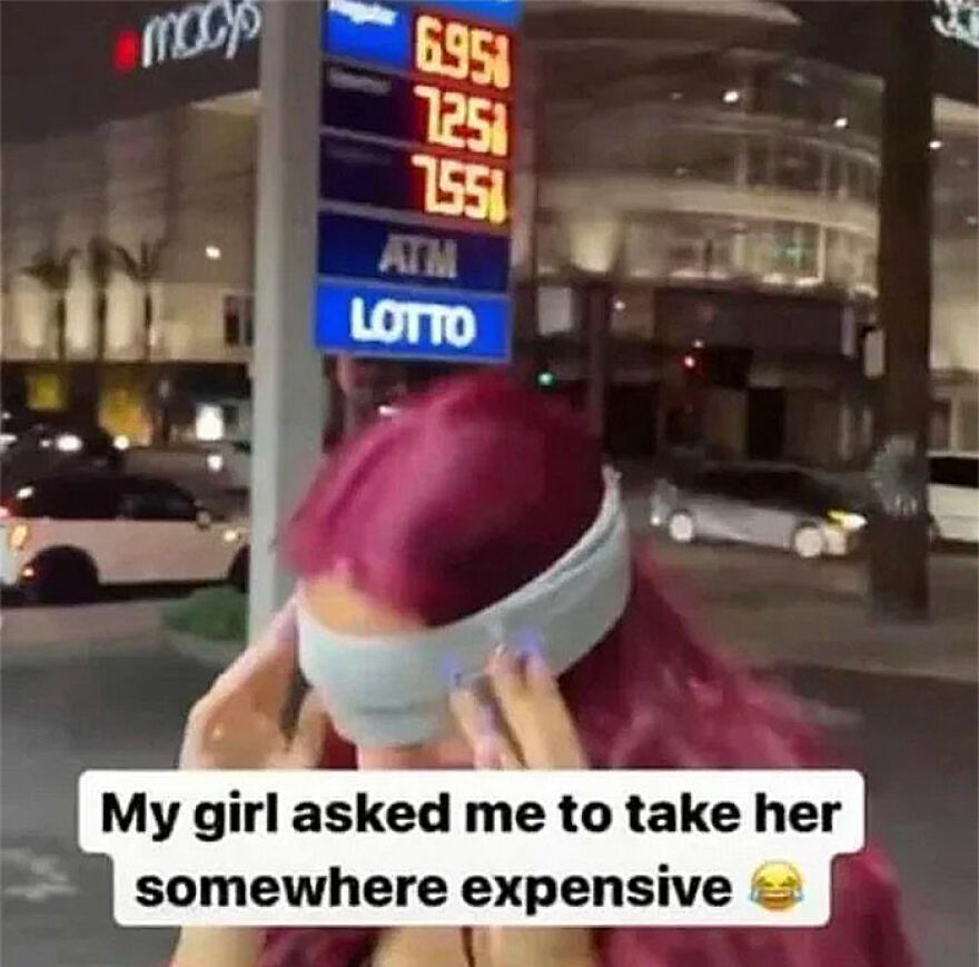 Woman blindfolded at gas station sign showing high prices