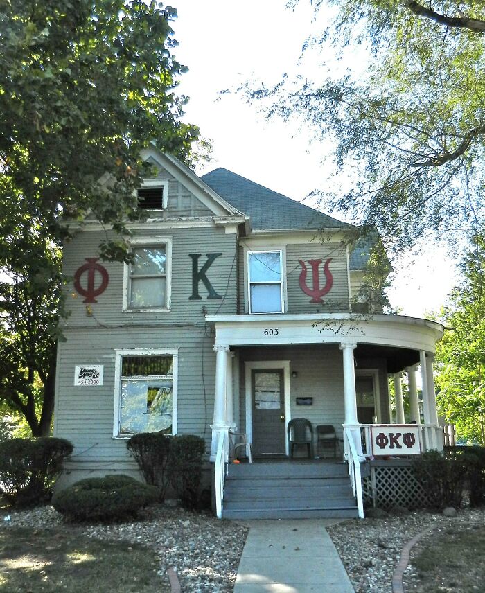 Old Greek fraternity house with symbols on exterior walls and porch