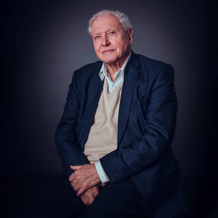 David Attenborough, a centenarian, posing against a dark background, looking serene. He credits his long life to a specific diet.