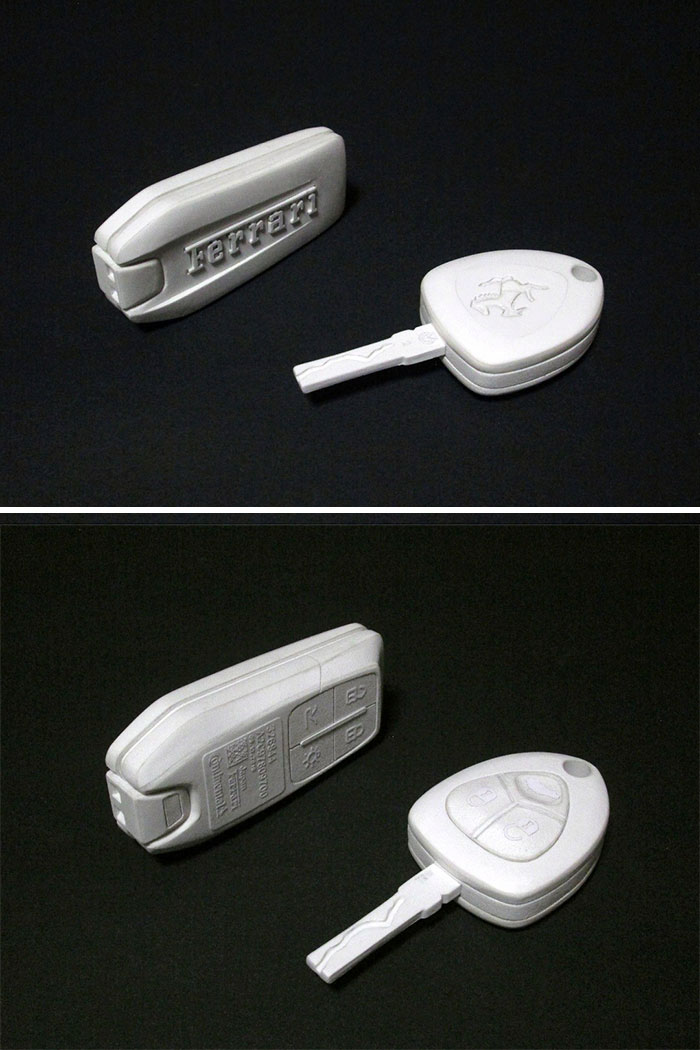Paper car key fobs with Ferrari branding and key buttons visible