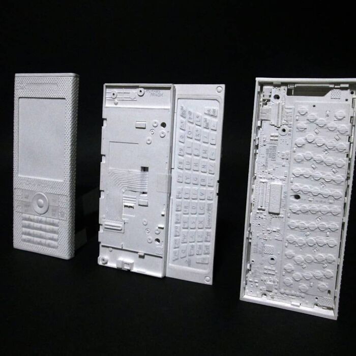 Disassembled paper phone parts showing keyboard and internal circuits