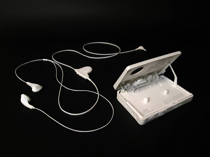 Paper cassette player with connected earphones on black surface