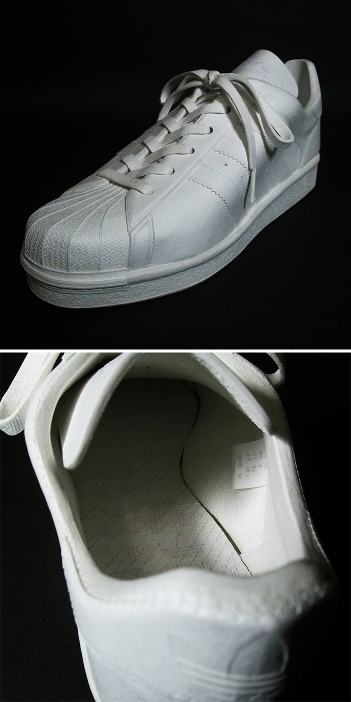 Paper sculpture of a white sneaker showing textured sole and laces