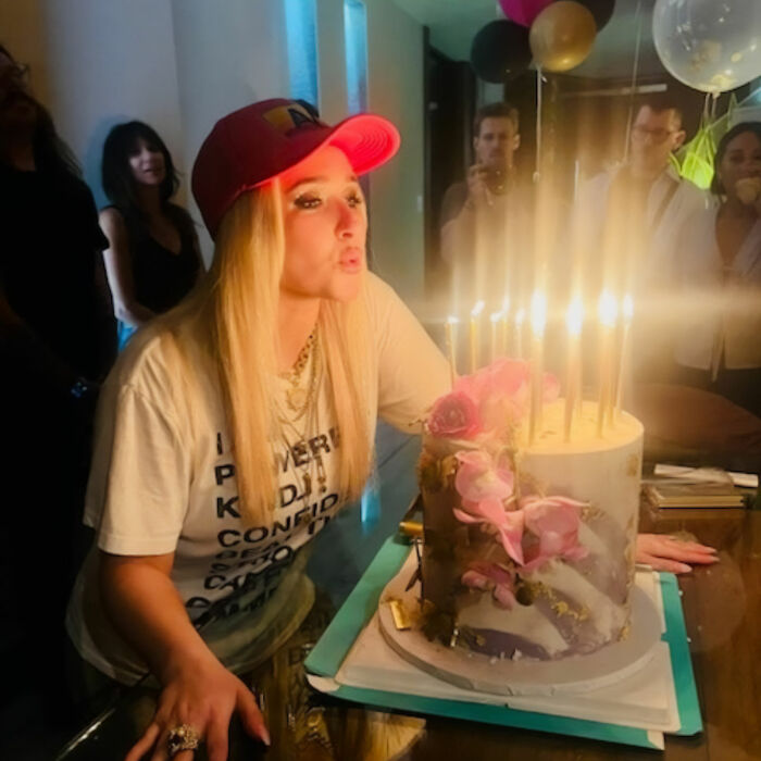 Hayden Panettiere blowing out candles on birthday cake at celebration