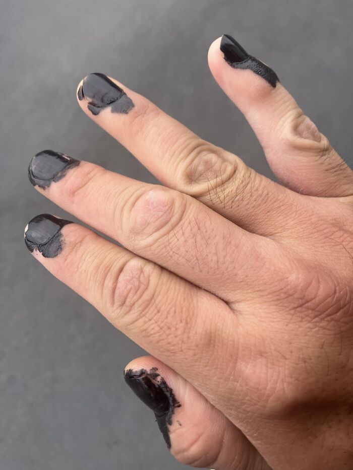 Hand with messy black nail polish showing imperfect but real wholesome moments