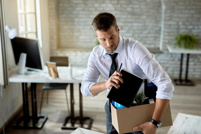 Man packing box with personal items in office scary inevitable moments