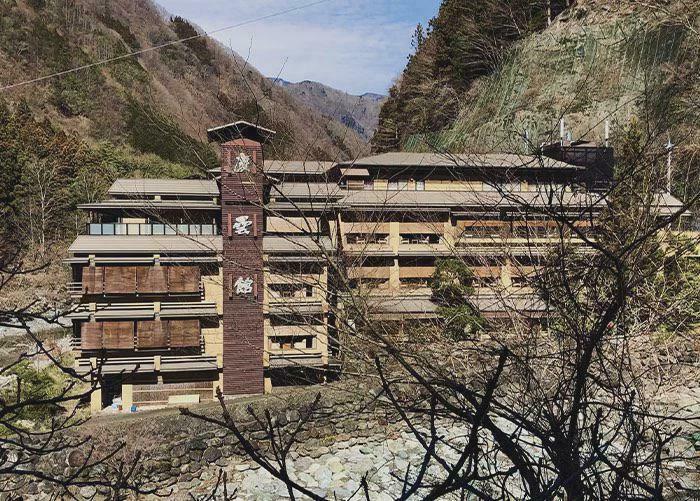 A large traditional Japanese hotel or ryokan nestled in a valley, an interesting post.