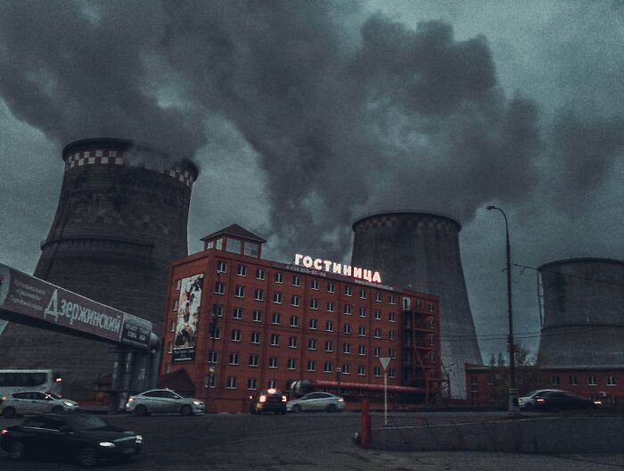 Polluted industrial urban hell scene with smoking cooling towers and red brick building