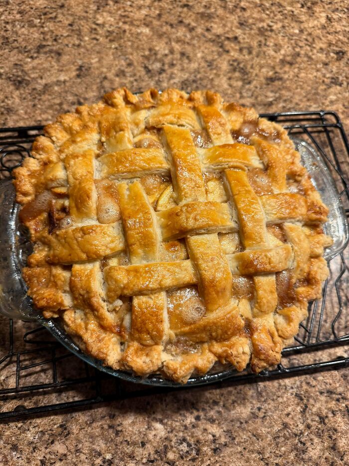 Baked pie with almond flakes and patterned fruit filling in kitchen