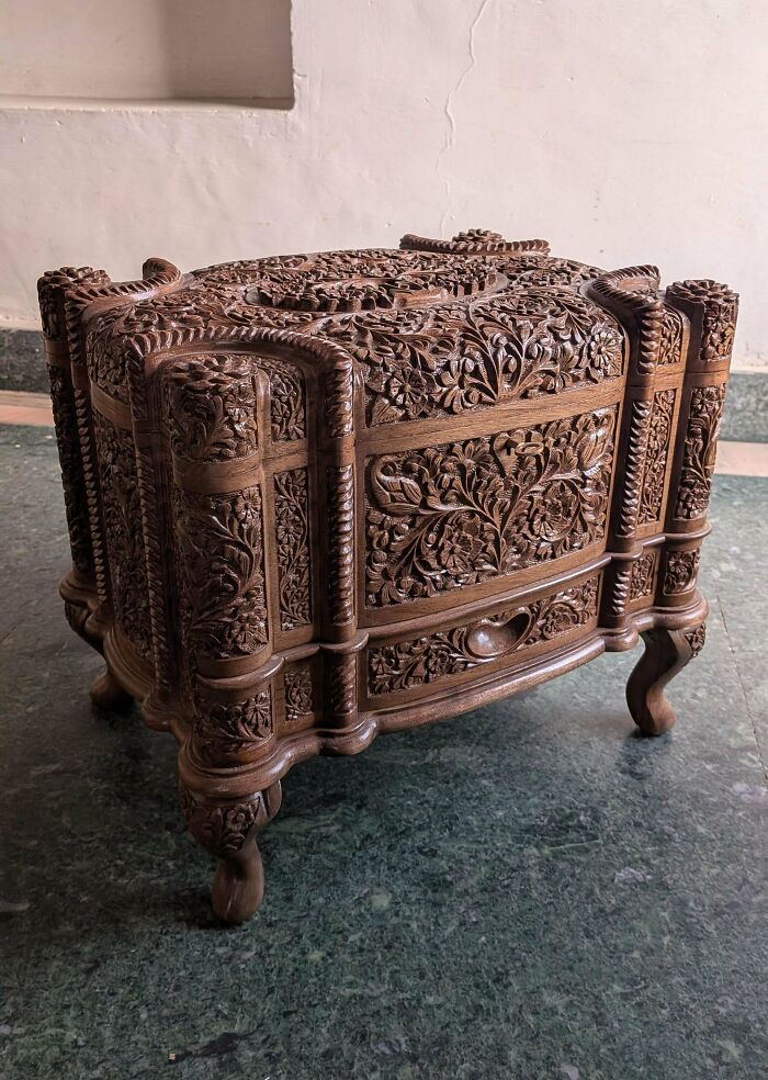 An intricately carved wooden chest with detailed floral patterns, a stunning example of handmade craftsmanship.